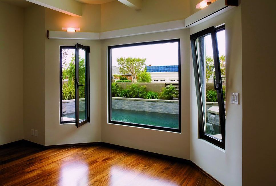 black aluminium tilt and turn windows open on a bay