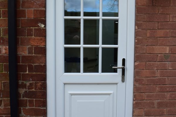 white uPVC residential door on a red brick building